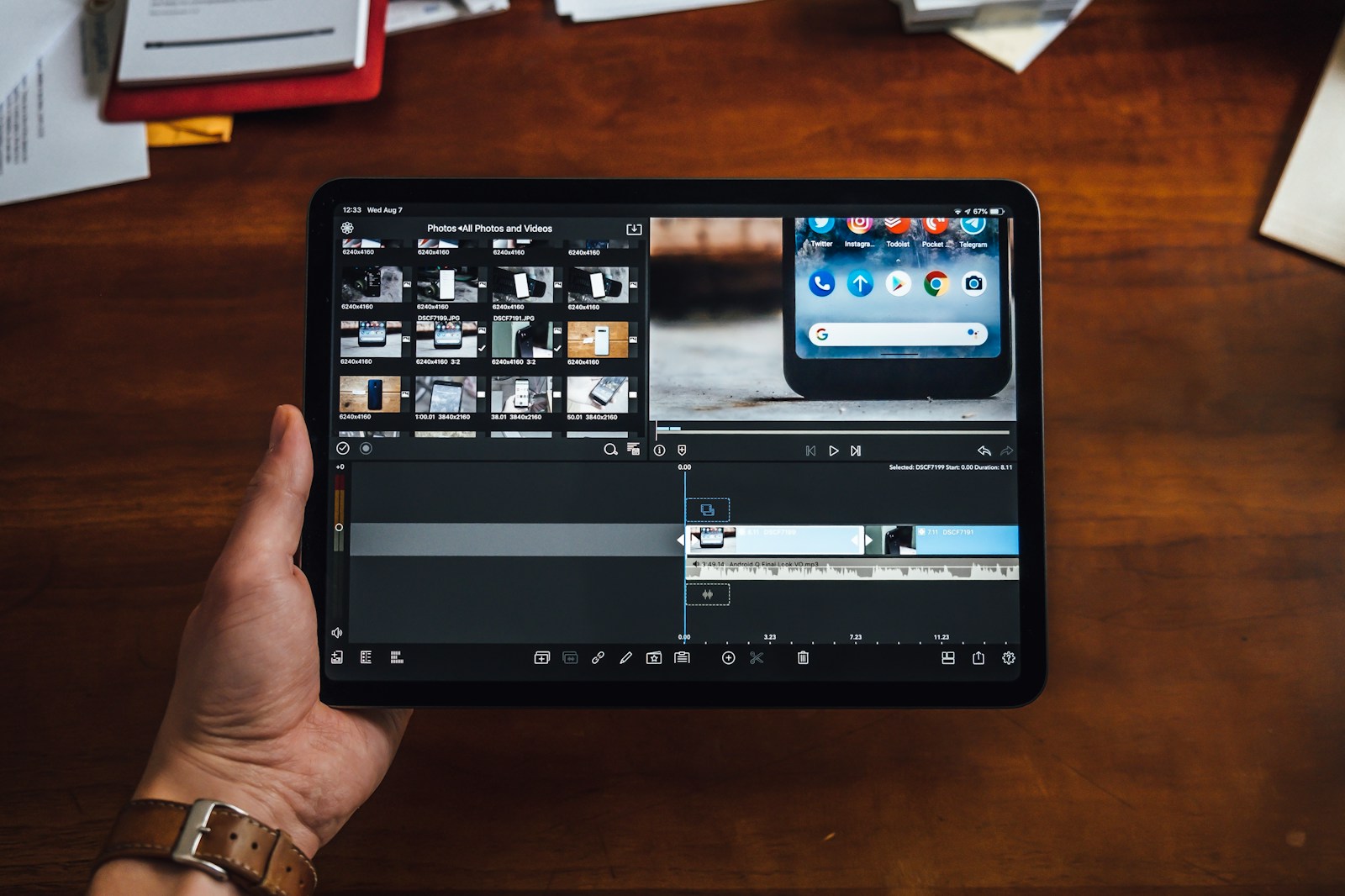 person holding black tablet computer showing video editor